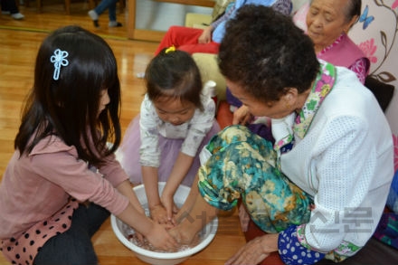 어린이들이 정성껏 할머니들의 발을 씻겨드리고 있다 김수연 기자 사진