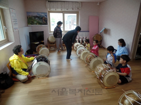 도봉산경로당 어르신이 도봉초등학교 학생들에게 장구를 가르치고 있다