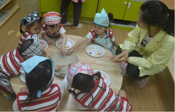 만 2세 어린이들이 영양사의 설명을 들으며 오복쌈을 만들고 있다 김수연 기자 사진