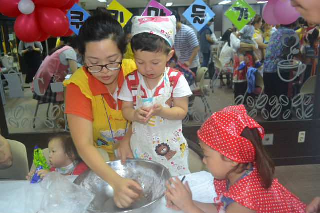 어린이와 엄마들이 한데 어울려 쿠키를 만들며 행복한 추억을 만들고 있다. (사진: 어린이와 엄마가 진지한 모습으로 반죽하고 있다)            김수연 기자 사진