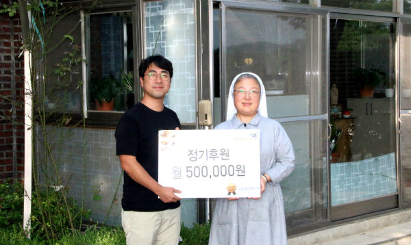 교촌에프앤비㈜ 김성훈 과장(왼쪽)과 생명의집 금주 수녀(오른쪽)가 기념촬영을 하고 있는 모습