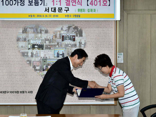 ‘서대문구 100가정 보듬기 사업’ 수혜자에서 후원자가 된 김해자 씨(오른쪽)가 문석진 서대문구청장에게 후원약정서를 전달하고 있다