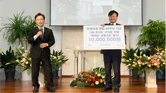 은광교회 나눔콘서트에서 김우영 은평구청장(오른쪽)이 1000만원을 전달받고 기념 촬영에 임했다