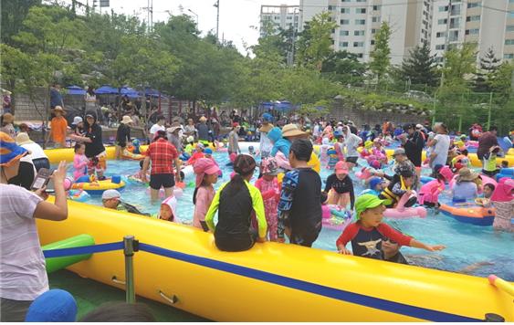 숭인초등학교 대규모로 펼쳐진 이동식 물놀이장에서 가족이 함께 더위를 식히고 있다 