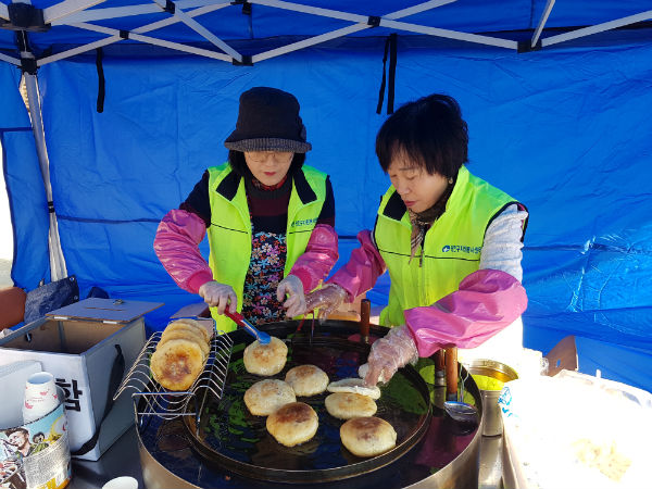 ▲광장동 자원봉사캠프 회원이 아파트 단지 앞에서 열린 행사장에서 사랑의 호떡을 만들고 있다