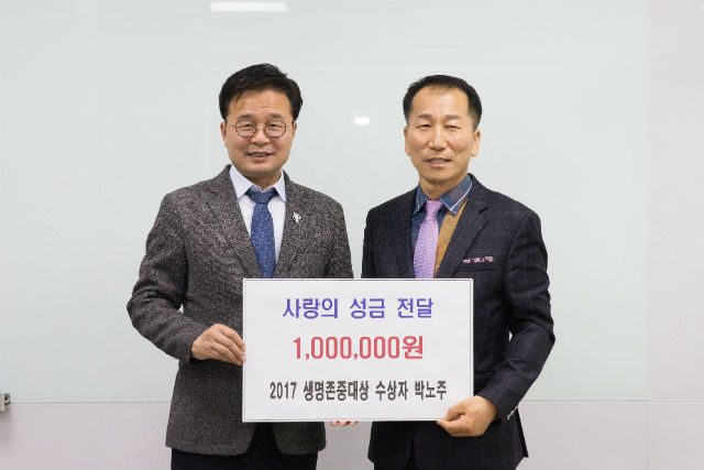 박노주 前은평구축구협회장(오른쪽)이 성금 전달식을 갖고 김우영 구청장과 기념 촬영하고 있다 