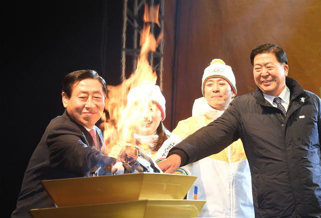 이용주 의장이 성화봉송 축하행사에서 성화대에 불을 붙이고 있다.(왼쪽부터 이용주 의장, 하히라 최수종 부부, 조길형 구청장)