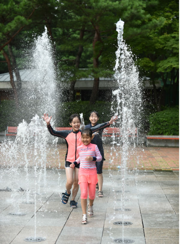 어린이들이 신내근린공원 바닥분수에서 물 놀이를 하며 즐거워하고 있다