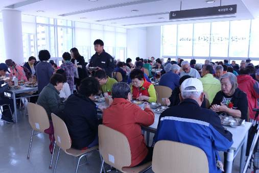 교촌에프앤비㈜ 임직원 봉사단이 수원시 광교노인복지관에서 진행한 어버이날 기념 행사에서 어르신들에게 식사를 대접하고 있다