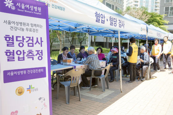 주민들이 서울여성병원 혈압·혈당 검진 부스에서 검진을 받고 있다