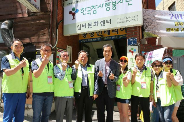 문석진 구청장(가운데)이 '한국참사랑봉사단' 자원봉사자들과 손가락 하트를 만들어 보이며 기념 촬영 하고 있다