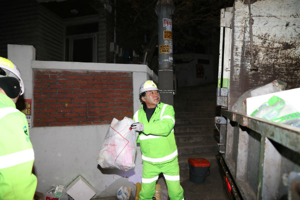 박준희 관악구청장이 배출된 재활용품을 수거차량에 싣고 있다