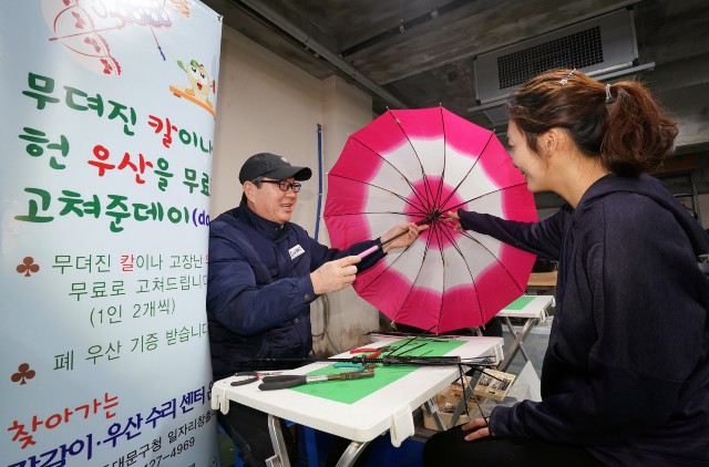 용신동 주민센터에서 ‘찾아가는 칼갈이‧우산수리센터’ 정비반이 고장난 우산을 무료로 수리하고 있다