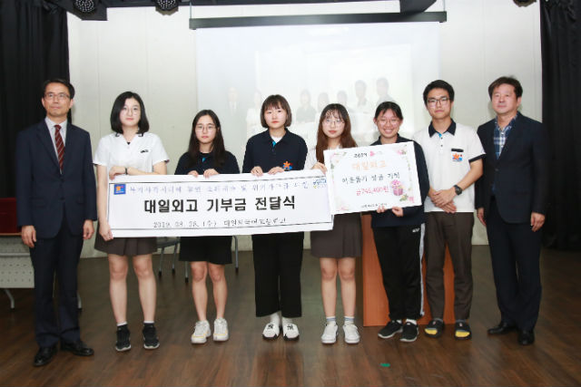 성북구 대일외고가 저소득 청소년을 위해 축제 수익금을 기부하고 관계자들이 기념 촬영을 하고 있다