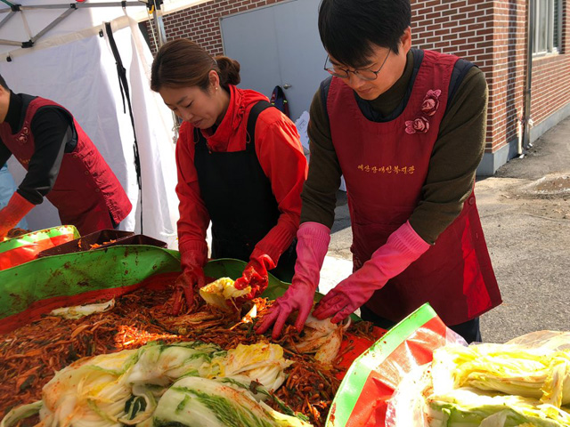 김장김치를 담그고 있는 봉사자들. (사진 왼쪽 자원봉사자, 오른쪽 신암우체국 홍원표 국장)