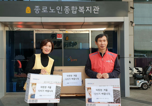 윤각현 한국마사회 종로지사장(오른쪽)이 종로노인종합복지관 이해경부장에게 겨울나기 물품을 전달하고 있다