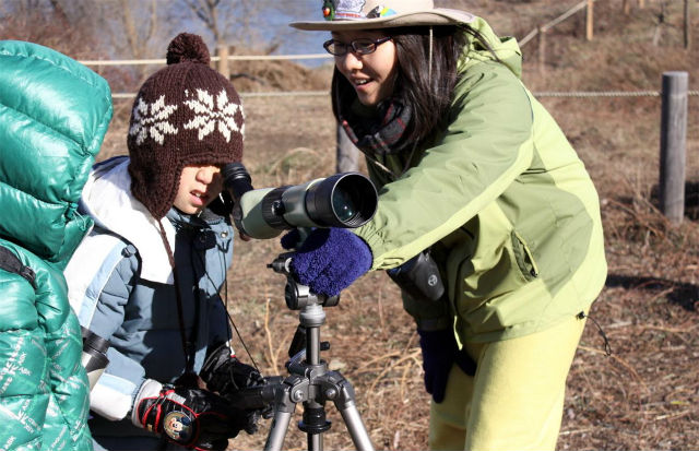  어린이가 조류관측용 망원경을 통해 겨울철새를 관찰하고 있다