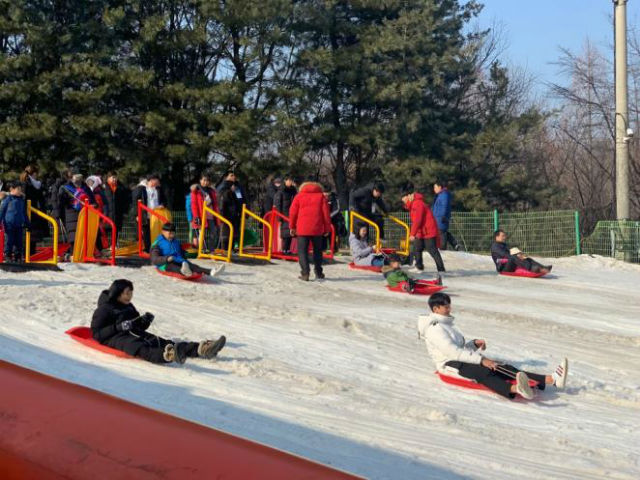 금천 겨울계절학교 참여자들이 신나게 눈썰매를 타고 있다