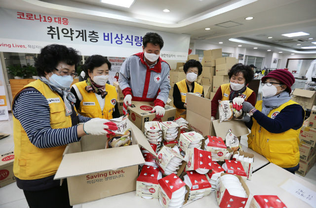 취약계층 비상식량을 포장하는 김상진 대한적십자사 서울특별시지사 사무처장(가운데)와 적십자 봉사원들