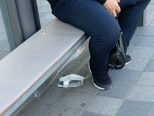 3월 16일 저녁 A 전철역 버스정류장에 버려진 마스크. 누군가의 생명을 지켜주던 마스크가 이맛살을 찌푸리게 하는 위해 물질이 돼 을씨년스럽게 나뒹굴고 있다                     장경근 기자 사진