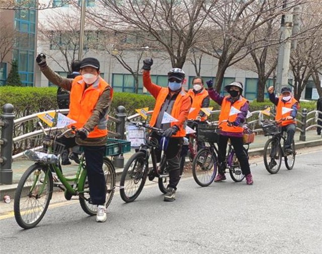 어르신들이 자전거에 희망 메시지 깃발을 달고 ‘건강 한 바퀴로 코로나 함께 이겨내요’ 캠페인에 참여하고 있다