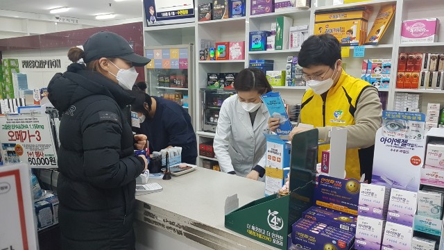 약국지원 봉사단이 공적마스크 판매 약국서 마스크판매를 돕고 있다