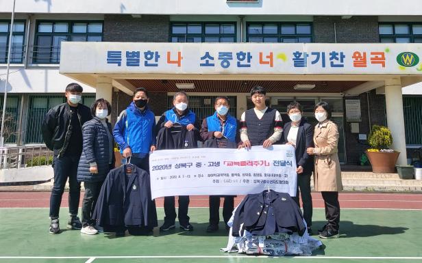 성북구청소년지도협의회가 지난 8일 월곡중학교를 방문해 세탁 수선된 교복을 학교 관계자에게 전달하고 있다