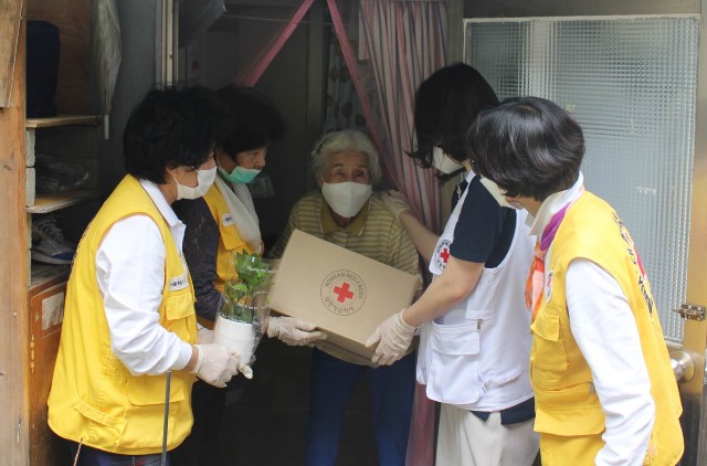 적십자 봉사원과 직원이 비상식량세트를 전달하고 있다