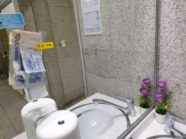경기도의회 청사 2층 화장실 세면대 거울에 부착돼 있는 '주인을 찾는 지폐' 모습  서울복지신문 사진