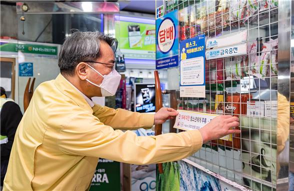 김선갑 구청장이 한 상가에 ‘담배·주류 불법 판매금지 스티커’를 부착하고 있다
