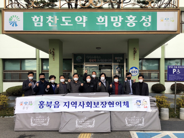 홍북읍 지역사회보장협의체 전기매트와 마스크를 기탁하고 기념촬영을 하고 있다