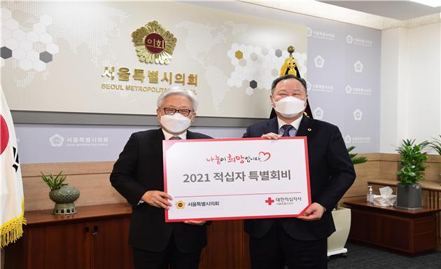 김인호 의장(오른쪽)이 김흥권 회장에게 적십자 특별회비를 전달하고 기념 촬영을 하고 있다