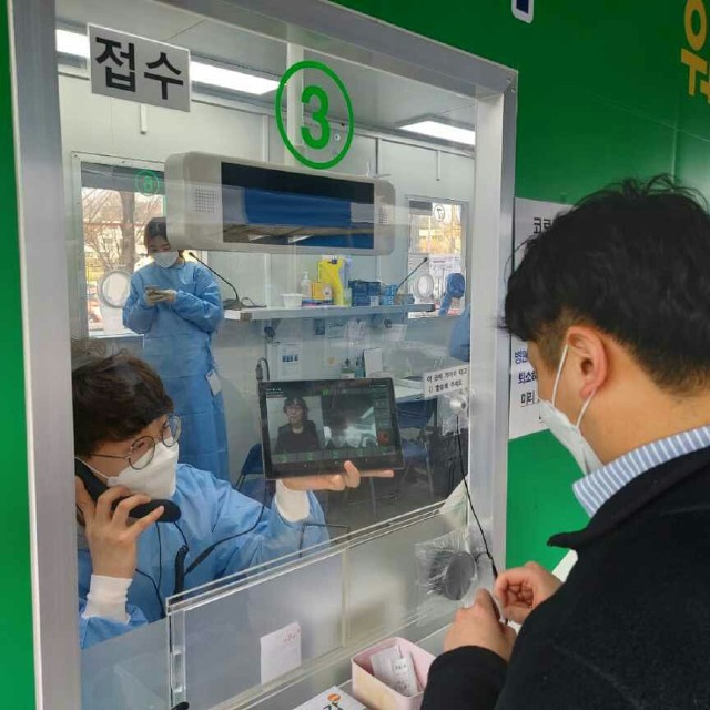 강북구 선별진료소 방문한 청각장애인과 의료진이 수어통역화상전화기로 대화하고 있다