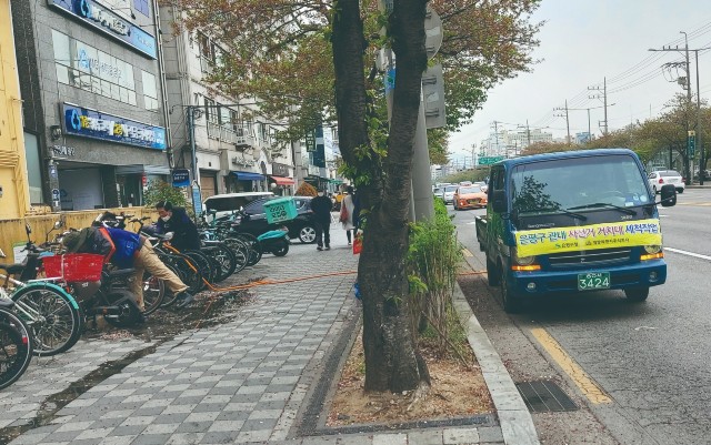 용역 업체 직원 3명이 정성스럽게 거치대를 세척하고 있다   서울복지신문 사진