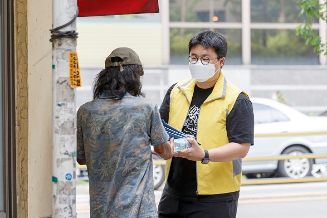지난 21일 마포구 직원이 거리 노숙인에게 폭염에 대비한 물과 마스크를 나눠주고있다