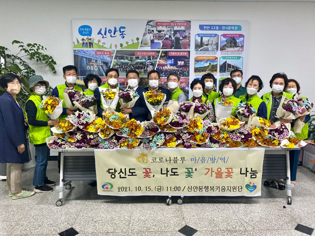 천안시 신안동 행복키움지원단이 가을꽃다발 나눔 행사를 갖고 기념 촬영을 하고 있다