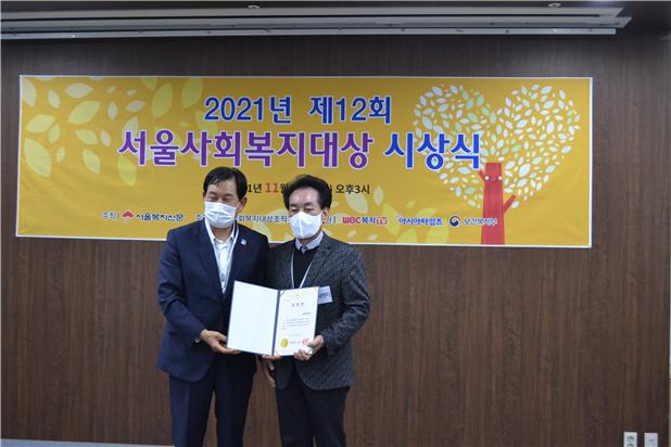 김흥철 대표(오른쪽)가 서울시장 단체 표창을 수상하고 기념 촬영을 하고 있다