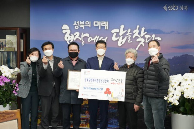 성북구 전통시장 연합회에서 기부금을 전달하고 기념촬영을 하고 있다