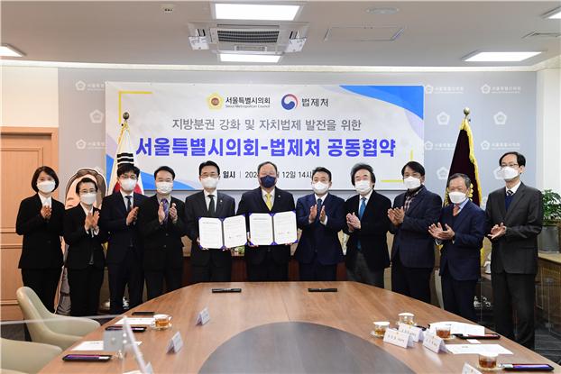 김인호 의장(가운데)이 법제처와 업무협약을 체결하고 관계자들과 기념 촬영을 하고 있다