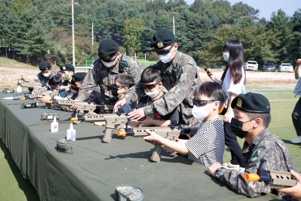 어린이들이 군장비 설명을 듣고 체험을 해보고 있다