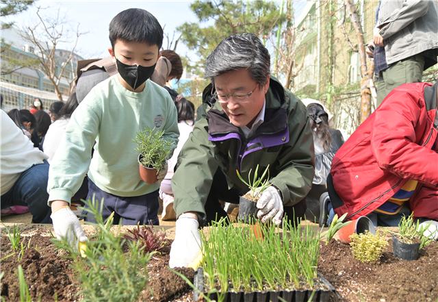 김길성 구청장이 남산초등학교에서 어린이와 꽃묘를 심고 있다
