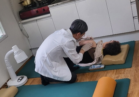 ▲ 구 소속 한의사가 경로당에서 침술 치료를 하고 있다